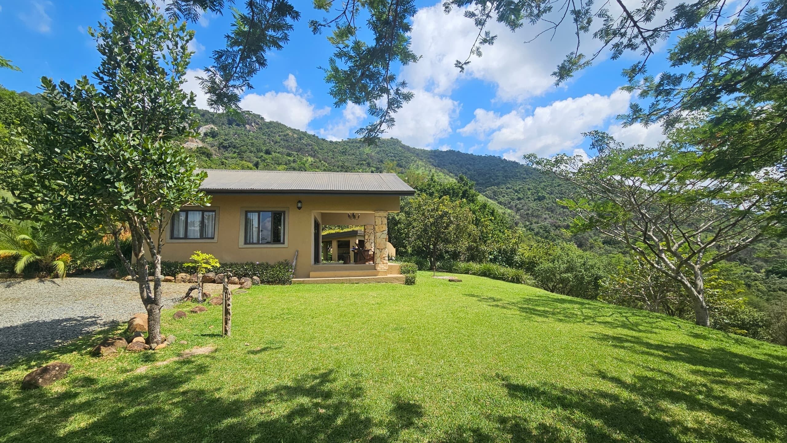 A two-story house with a stone facade, a front porch, and a well-maintained lawn.