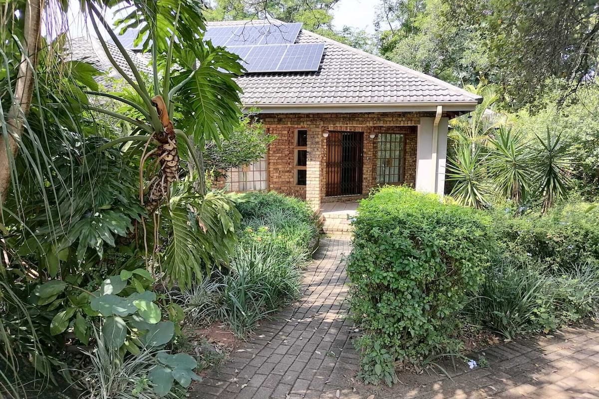 A house with a brick exterior, a tiled roof, and solar panels.