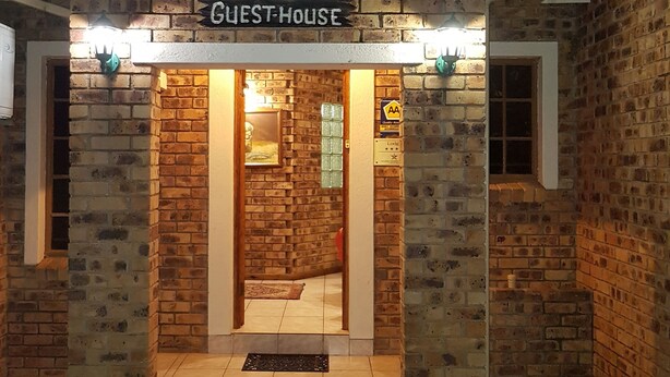 A brick building with a sign reading "SHINGALANA GUEST-HOUSE".