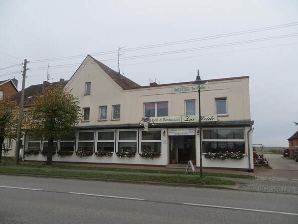A two-story building with a sign reading "Hotel & Restaurant Zur Heide."