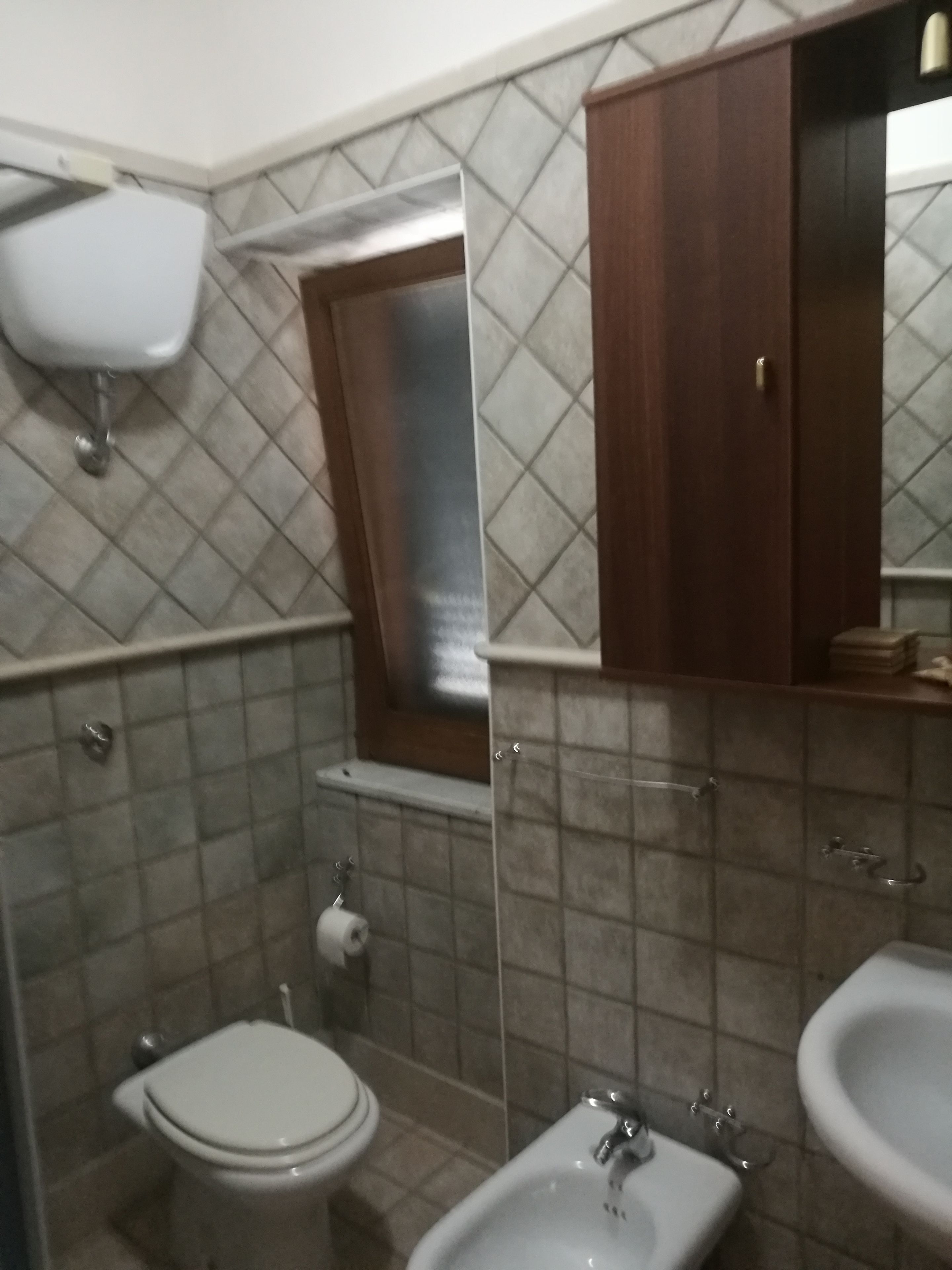 Et badeværelse med toilet, bidet og håndvask.