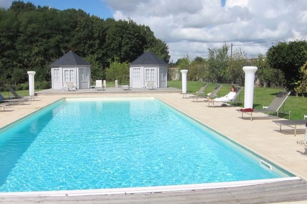 Una piscina al aire libre, sombrillas, tumbonas