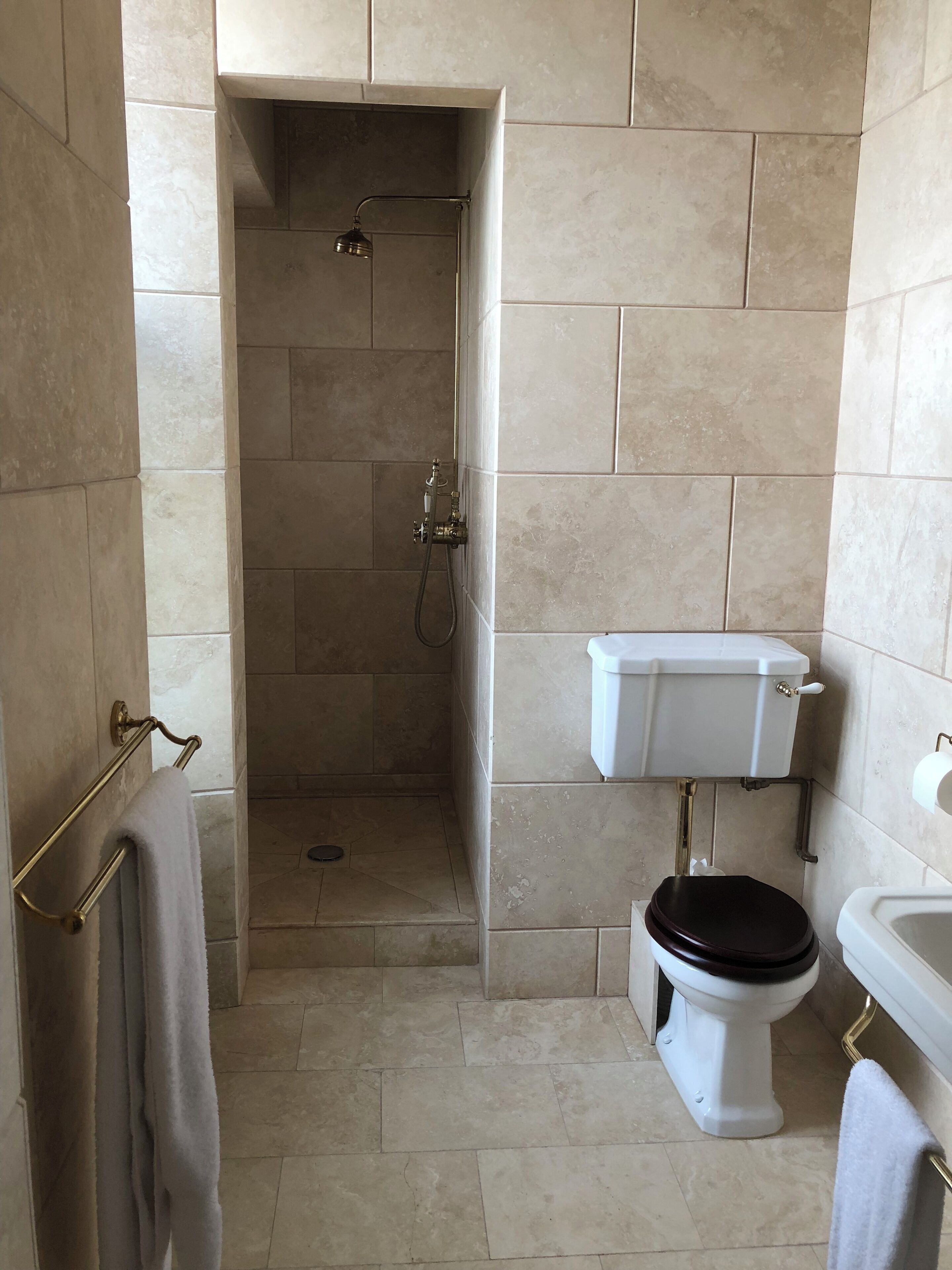 A bathroom with a shower, toilet, and sink.