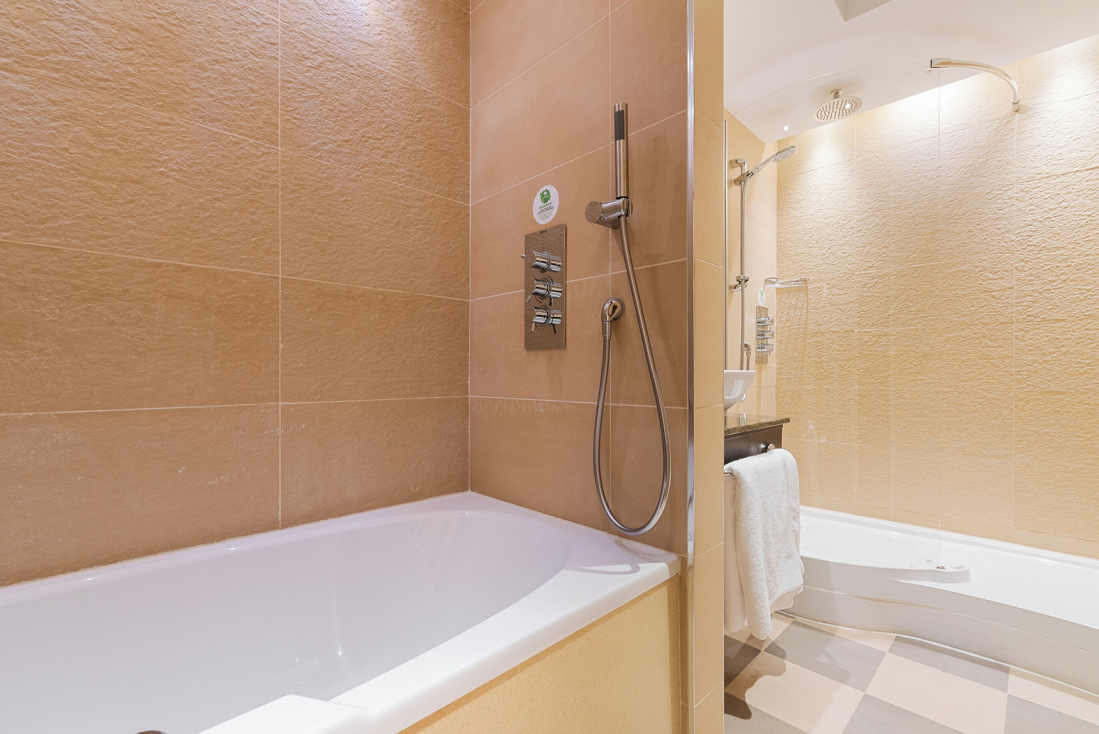 A bathroom with a bathtub, a shower area, and a toilet.