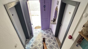 A staircase with a wooden handrail leading to a door with a purple handle. - Endaxi (Bozcaada)