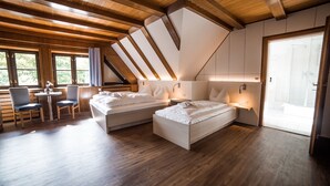 A modern bedroom with two beds, a desk, and a chair. - Hotel zur Fähre (Greifswald)