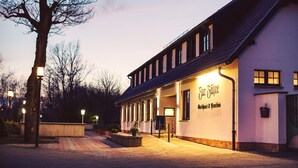 A building with a sign reading "Haus Fährte" and a covered outdoor area with a bench. - Hotel zur Fähre (Greifswald)