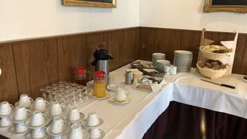 Una mesa de buffet con diversos alimentos, cristalería y un cuchillo.