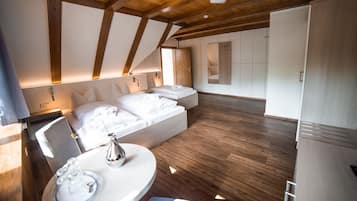 Una habitación de hotel moderna con techo de madera, una cama con ropa blanca, una mesita de noche con lámpara y vista al interior de la habitación.