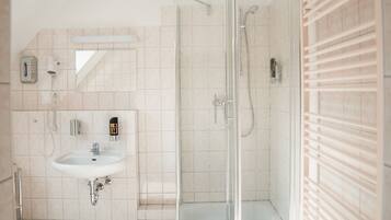 Un baño moderno con cabina de ducha de vidrio, un lavabo y un espejo.