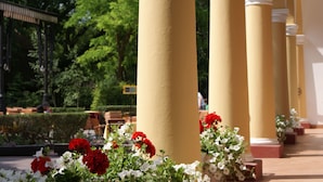 A series of yellow columns with white bases, surrounded by white and red flowers.
