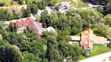 Vista aérea de um bairro residencial com várias casas, um estacionamento e um ônibus.