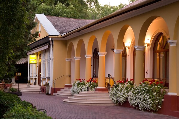 A building with a yellow facade, arched windows, and a staircase leading to the entrance. - Geréby Kúria Hotel és Lovasudvar (Lajosmizse)
