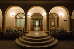 A grand entrance with three arched doorways, a central staircase, and a well-lit interior visible through the doors. - Geréby Kúria Hotel és Lovasudvar (Lajosmizse)