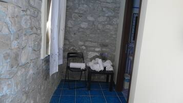Relax in this serene bathroom with a bathtub, towels, and a comfortable chair.