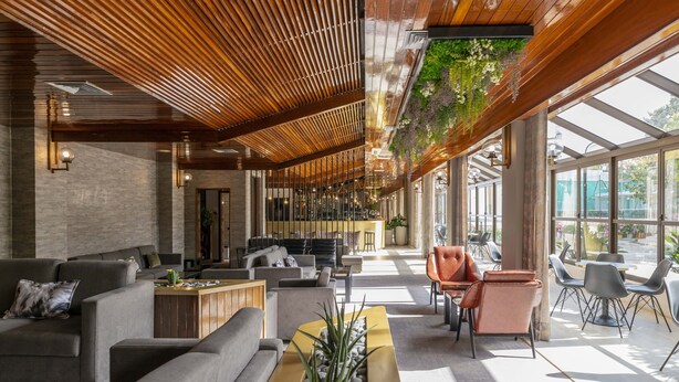 Un moderno hall con sofás, una mesa de centro y una planta colgante.