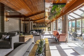 A modern lobby with sofas, a coffee table, and a hanging plant. - D. Afonso Hotel & SPA (Leiria)