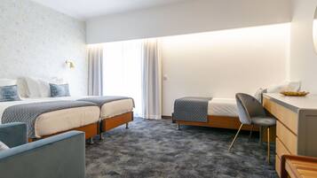 Habitación de hotel con dos camas, un escritorio y una silla.