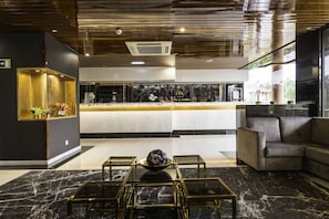A modern lobby with a reception desk, seating area, and a decorative bowl on a glass table. - D. Afonso Hotel & SPA (Leiria)
