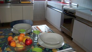 A dining table with a fruit bowl, plates, and cutlery. - Capri residence in Vicenza (vicenza)