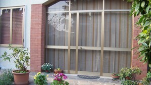 A patio with potted plants and a large sliding glass door. - Capri residence in Vicenza (vicenza)