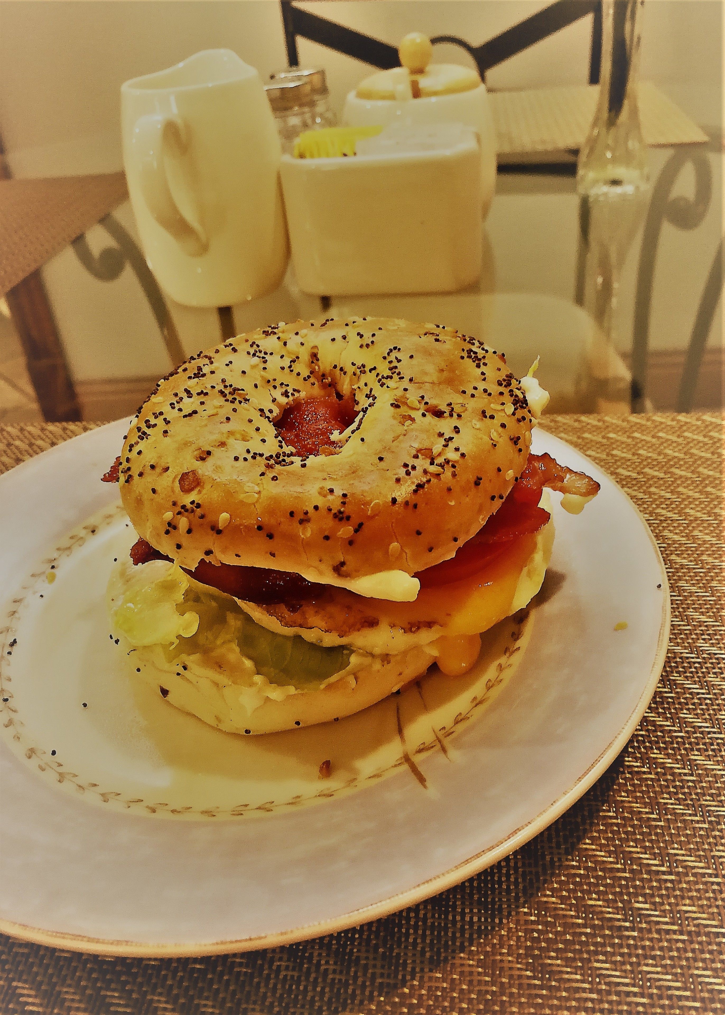 Un sándwich de desayuno sobre un plato con un mantel tejido.