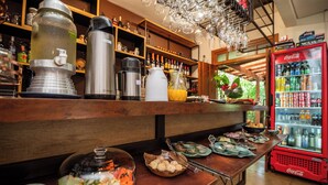 A buffet setup with various food items and beverages, including a Coca-Cola refrigerator.