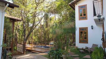 A house with a swimming pool, surrounded by a garden and trees.