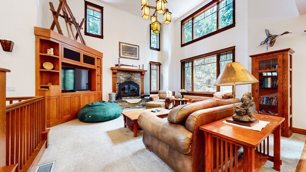 A spacious living room with a fireplace, wooden furniture, and large windows. - Timbers 5 Large Luxury Home with Two Master Suites, Perfect for Families by RedAwning (Mammoth Lakes)