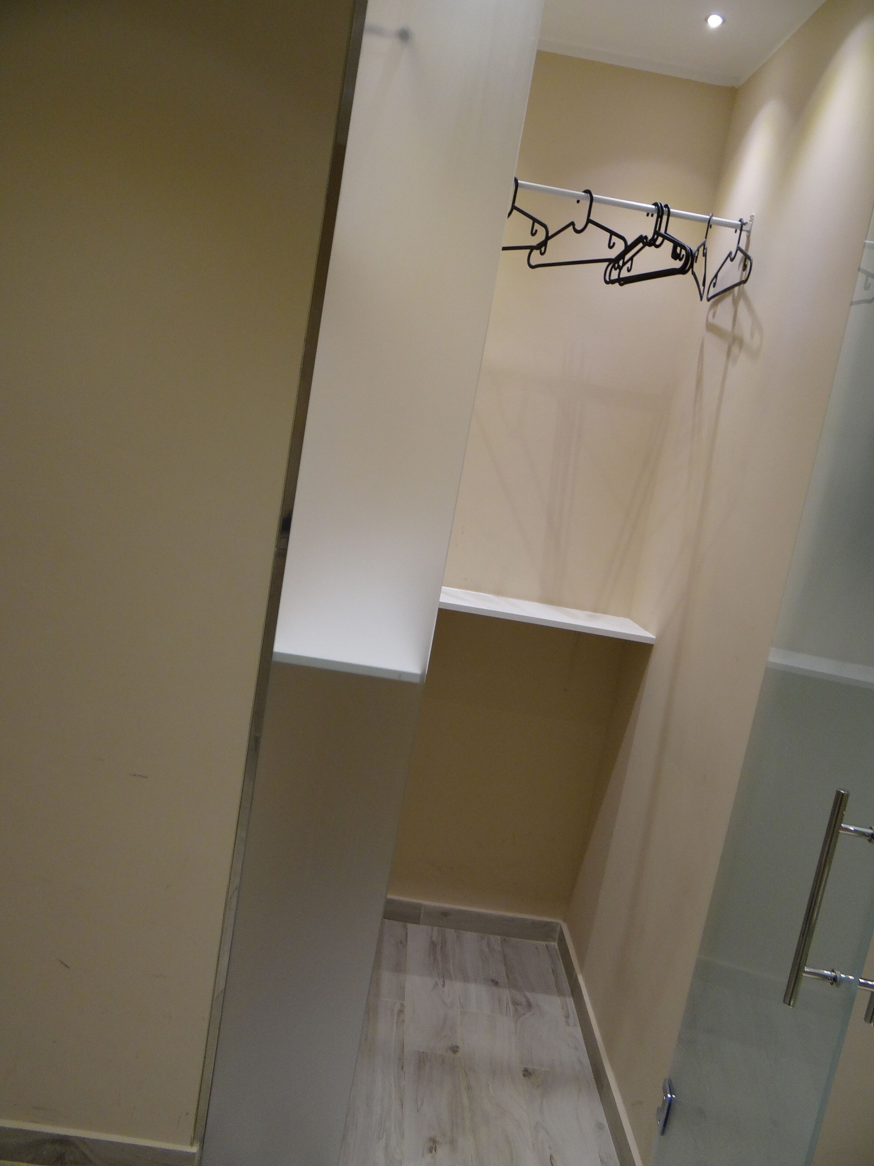 A bathroom with a shower, a towel rack, and a mirror.