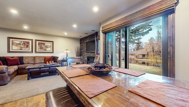 Una sala moderna con una mesa de comedor de madera, un sofá de cuero y una chimenea.