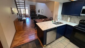 A modern kitchen with dark blue cabinets, a stainless steel sink, and a built-in oven. - Fox Pine Lodge 4 Bed 4 Bath Condo (Copper Mountain)