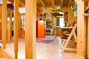 Un intérieur en bois comprenant un coin cuisine, un réfrigérateur et une table à manger avec des chaises.