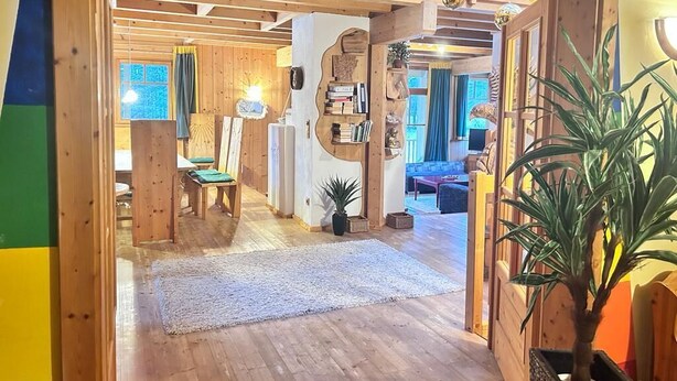 Un intérieur en bois comprenant un coin repas, un salon et un escalier.
