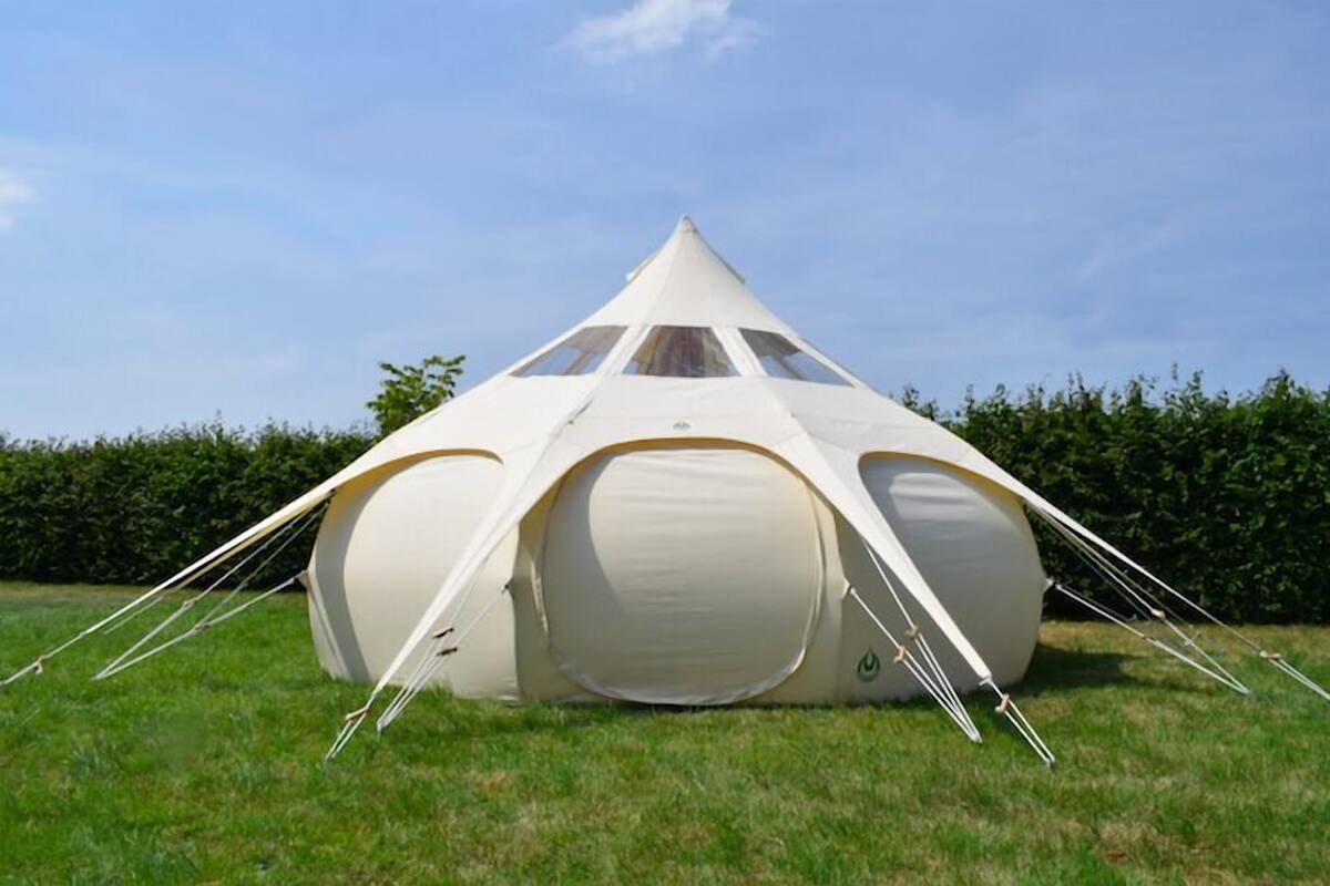 A geodesic dome tent with a central circular window and multiple entry points.