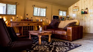 Ein gemütliches Wohnzimmer mit einer Ledersofa, einem Holztisch und einem gemusterten Teppich.