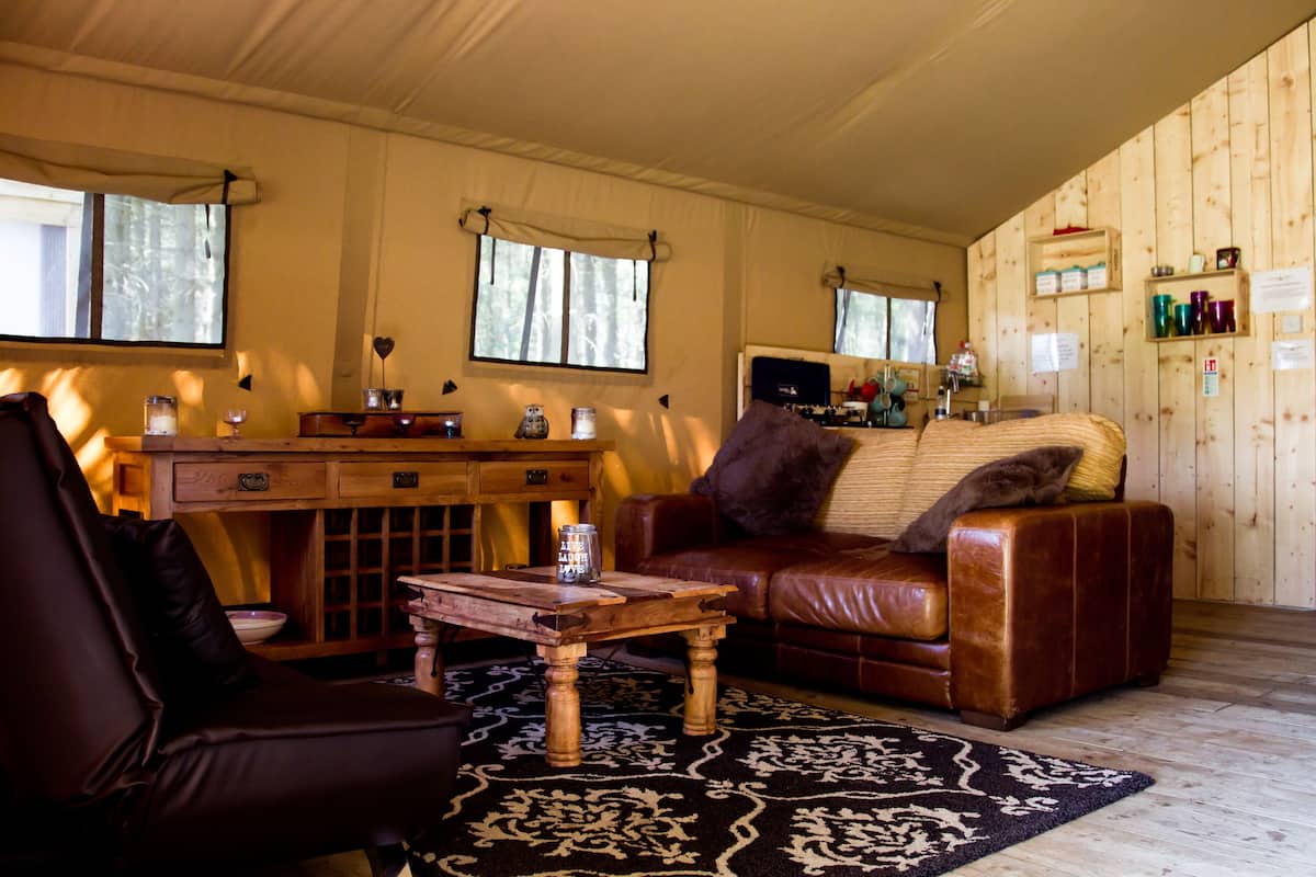 A cozy living room with a leather sofa, a wooden coffee table, and a patterned rug.