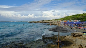 A beach with clear blue water, rocky shore, and umbrellas. - Masseria Faresalento (Gallipoli)