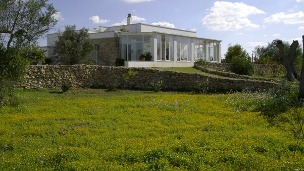 A modern house with a stone wall and a glass conservatory. - Masseria Faresalento (Gallipoli)