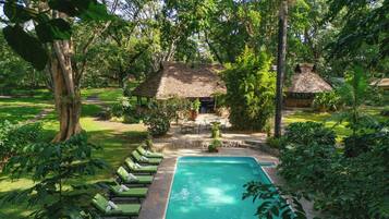 Una piscina al aire libre, sillones reclinables de piscina