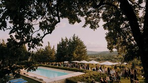 A poolside area with a swimming pool, lounge chairs, and a grassy lawn. - Il Verreno (Ambra)