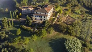 An aerial view of a villa surrounded by lush greenery and rolling hills. - Il Verreno (Ambra)