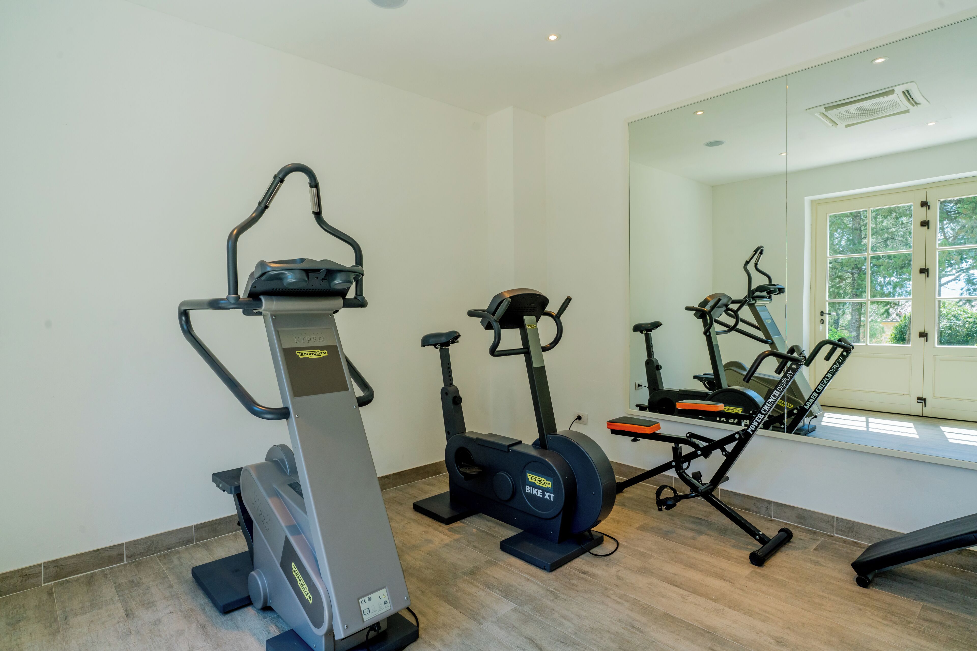A home gym with a treadmill, elliptical, and stationary bike.