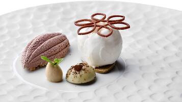 Un plato de postre con mousse de chocolate, helado de vainilla y un anillo decorativo de chocolate.