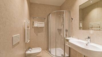 Un baño moderno con ducha de vidrio, lavamanos e inodoro.