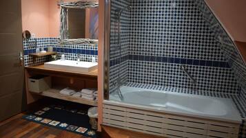 Une salle de bain avec une douche, un lavabo et un miroir.