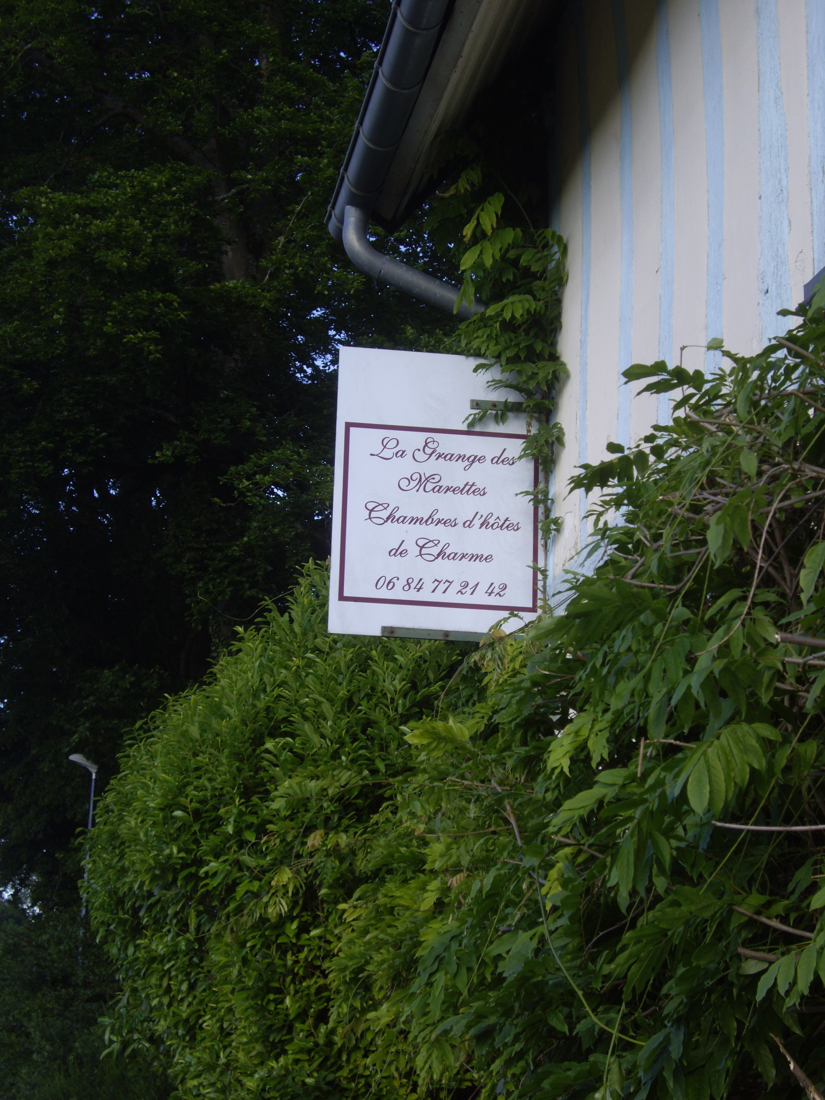 A sign for La Grange des Marettes, Chambres d'hotes de Charme, with a phone number.