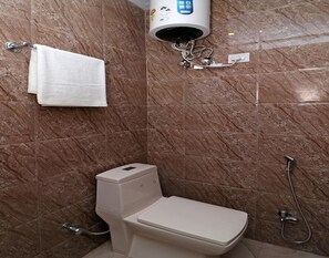 A bathroom with a toilet, a towel rack, a hairdryer, and a shower head. - OYO 12754 Hotel The Best (New Delhi)