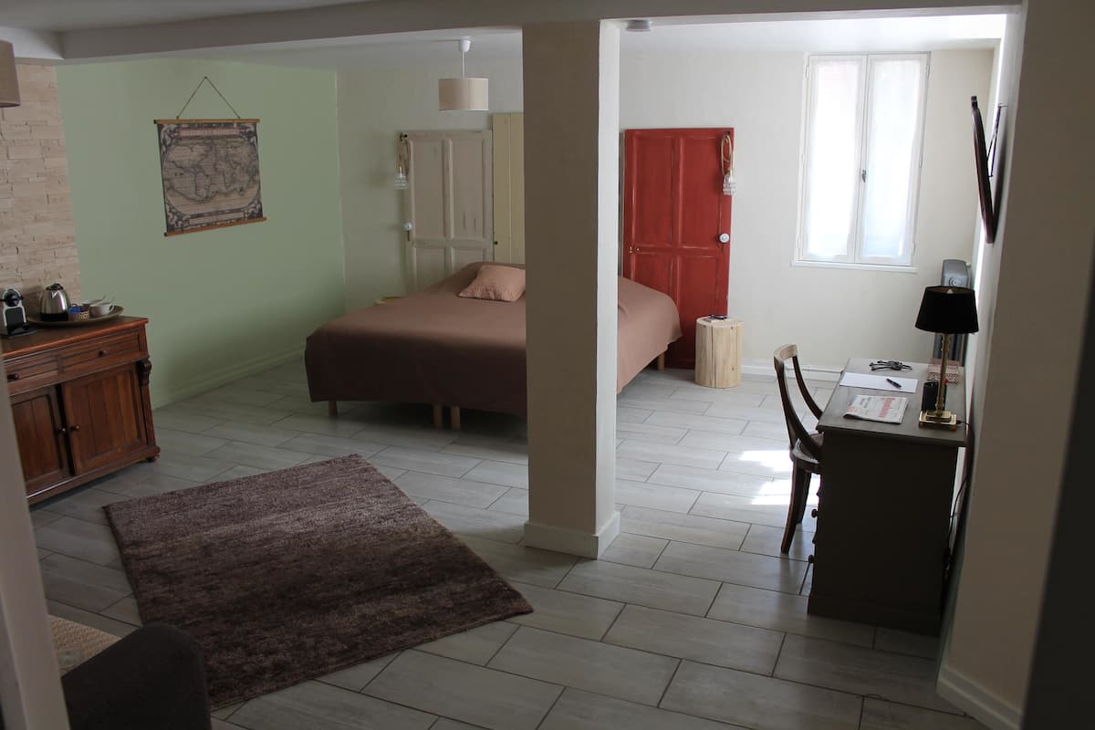 Une pièce avec un lit, un bureau et une carte accrochée au mur.