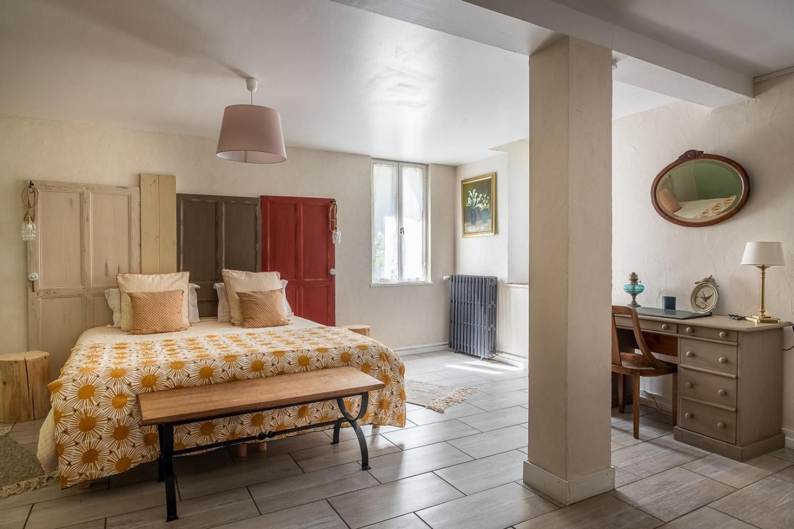 Une chambre à coucher avec un lit, un bureau, une chaise, un radiateur et une fenêtre.